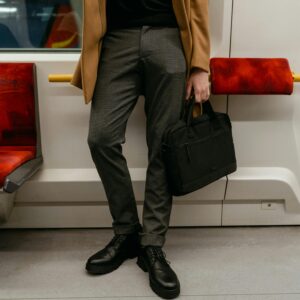 Man Holding a Black Bag Inside the Train